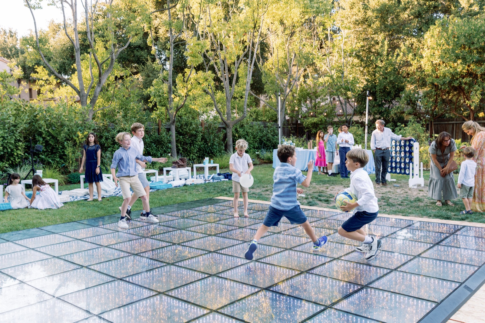 Children playing with a soccer ball on a mirrored dance floor at a bat mitzvah